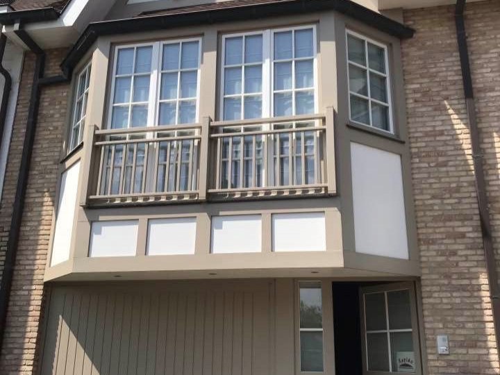 Woning met witte raamkaders en balkons in Knokke